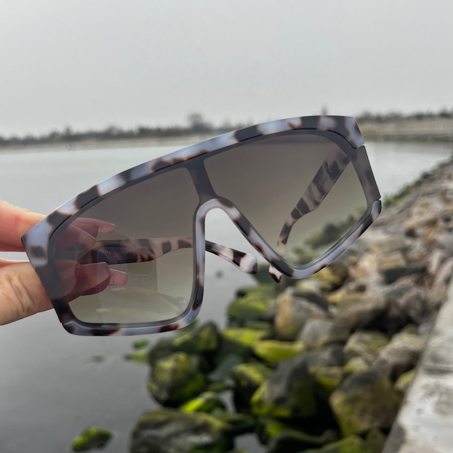 Milky - solbriller med leopardmønstret stel med røget / brune brilleglas. Dropps By Szhirley. Dansk design. Eksklusive solbriller. Designet af Szhirley. Solbriller for 2024