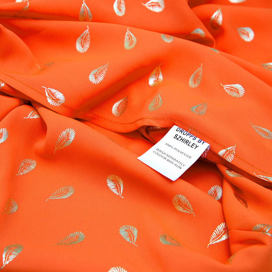 Breeze - Kimono i blodappelsin farve med fjerprint i guld - One Size. Designet af Szhirley. Inspireret af Catching Dreams kollektionens guldfjer
